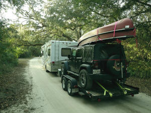 Motorhome pulling Jeep and canoes